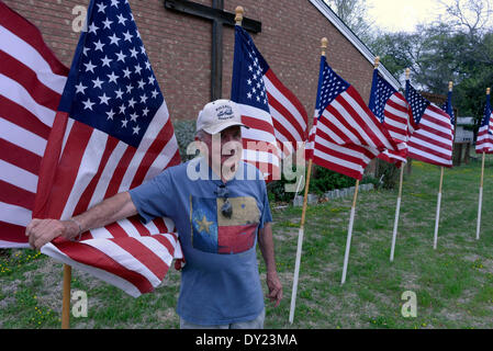 L'homme définit les drapeaux à l'Église chrétienne centrale pour rendre hommage aux victimes de la prise de poste de l'armée à Fort Hood à Killeen Texas Banque D'Images