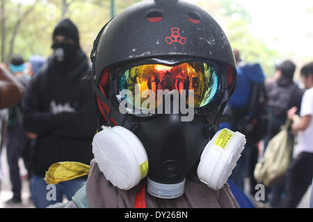 Caracas, Venezuela - le 3 avril 2014 : un manifestant couvrir son visage et protège lui-même des gaz lacrymogènes dans une manifestation à l'Université centrale du Venezuela (UCV). Credit : Rafael A. Hernández/Pacific Press/Alamy Live News Banque D'Images