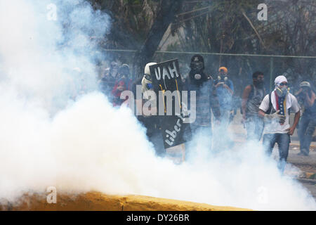 Caracas, Venezuela - le 3 avril 2014 : un manifestant le protège de l'auto-portrait avec un bouclier de fortune des gaz lacrymogènes lancés par la police à une émeute à l'extérieur de l'Université centrale du Venezuela (UCV). Credit : Rafael A. Hernández/Pacific Press/Alamy Live News Banque D'Images