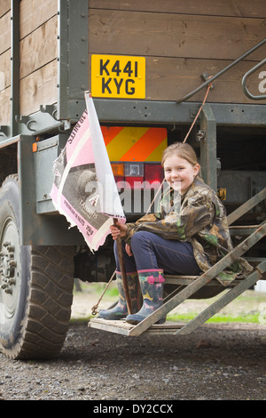 Une jeune fille du batteur bush tenant un drapeau fait maison alors qu'il était assis à l'arrière d'un camion ou d'armes à feu fouets sur un tournage Banque D'Images