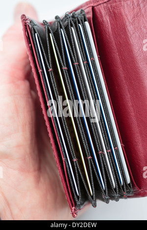 Woman's hand holding red un portefeuille porte-carte avec des fentes contenant des cartes de débit et de crédit de la banque. Angleterre Royaume-uni Grande-Bretagne Banque D'Images