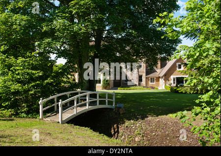 Pont de bois sur le jardin en flux de ferme du xixe siècle Banque D'Images