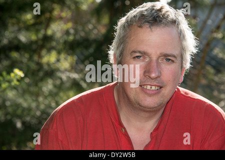 Un homme aux cheveux gris dans un t-shirt rouge Banque D'Images