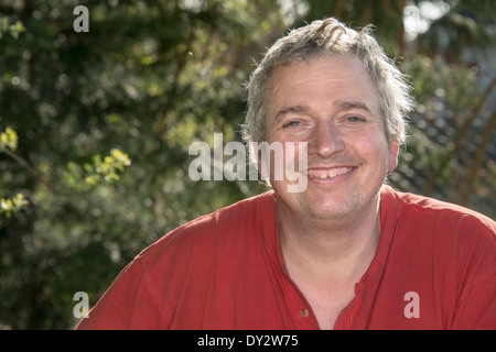 Un homme aux cheveux gris dans un t-shirt rouge Banque D'Images