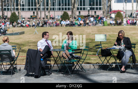 Les visiteurs de Bryant Park à New York profitez de beau temps pendant leur heure de déjeuner Banque D'Images