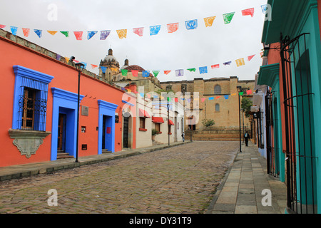 Les bâtiments aux couleurs vives, le long de la rue pavée à l'église en arrière-plan à Oaxaca, Mexique Banque D'Images