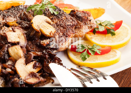 Côtelette de porc frit aux champignons et frites Banque D'Images