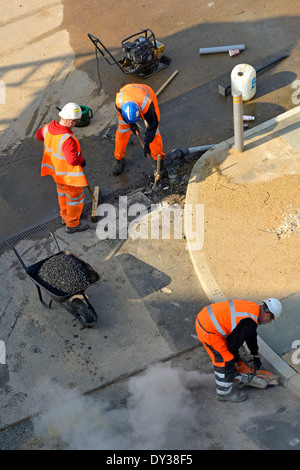 Regardant vers le bas sur des ouvriers effectuant des travaux de réparation de la chaussée Banque D'Images