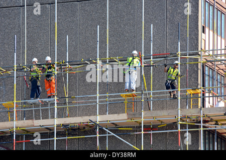 Ouvriers érigeant des échafaudages dans le bloc de logements sociaux obsolètes avant la démolition de biens immobiliers du Sud développement Heygate Southwark London England Banque D'Images