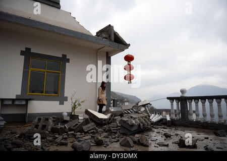 Yongshan, la province chinoise du Yunnan. 5ème apr 2014. Un villageois se distingue en plus de sa maison endommagée dans le comté de Yongshan, sud-ouest de la province chinoise du Yunnan, le 5 avril 2014. Au moins 25 personnes ont été blessées et 21 000 déplacés lorsqu'un tremblement de terre de magnitude 5,3 coincé Yongshan tôt le samedi. Credit : Hu Chao/Xinhua/Alamy Live News Banque D'Images