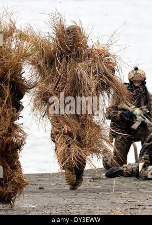 Deux tireurs d'camourflaged rush retour à la voile au cours d'une présentation militaire à Eckernfoerde, Allemagne, 5 avril 2014. Les plongeurs sous-marins La société a célébré son 50e anniversaire le 1er avril 2014. La société est l'une des unités de combat commando oldes dans la Bundeswehr et à l'avenir, deviendra un bataillon dans son propre droit comme un commando des forces spéciales de la marine allemande. Photo : Carsten Rehder/dpa Banque D'Images