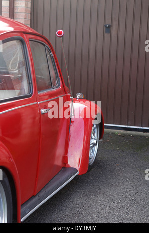 Classic VW Coccinelle rouge garée devant une porte de garage, Janvier 2014 Banque D'Images