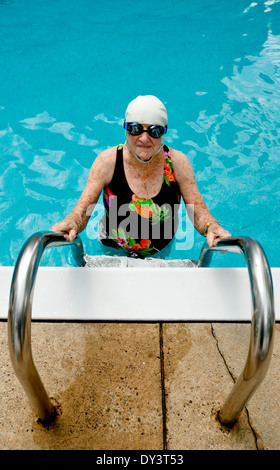Une personne âgée femme en maillot de bain, lunettes de natation et cap jouit d'un style de vie sain et reste jeune par la natation. Banque D'Images