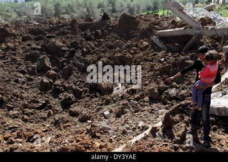 La ville de Gaza, bande de Gaza, territoire palestinien. 6ème apr 2014. Regardez les Palestiniens sur les dommages causés à la suite d'une frappe aérienne israélienne sur les terres agricoles dans la région de Beit Hanoun au nord de la bande de Gaza, le 6 avril 2014. L'aviation israélienne a attaqué plusieurs sites dans la bande de Gaza Dimanche, sources des deux côtés a déclaré, quelques heures après une fusée à partir de l'enclave palestinienne assiégée frapper Israël Crédit : Ramadn Al-Agha APA/Images/ZUMAPRESS.com/Alamy Live News Banque D'Images