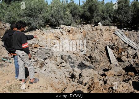 La ville de Gaza, bande de Gaza, territoire palestinien. 6ème apr 2014. Regardez les Palestiniens sur les dommages causés à la suite d'une frappe aérienne israélienne sur les terres agricoles dans la région de Beit Hanoun au nord de la bande de Gaza, le 6 avril 2014. L'aviation israélienne a attaqué plusieurs sites dans la bande de Gaza Dimanche, sources des deux côtés a déclaré, quelques heures après une fusée à partir de l'enclave palestinienne assiégée frapper Israël Crédit : Ramadn Al-Agha APA/Images/ZUMAPRESS.com/Alamy Live News Banque D'Images