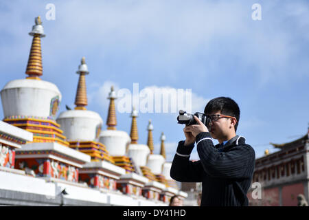 Huangzhong County, Province de Qinghai en Chine. 6ème apr 2014. Un touriste takács photos dans le monastère de Kumbum à Huangzhong Comté de Xining, capitale de la province du Qinghai dans le nord-ouest de la Chine, le 6 avril 2014. Le Monastère de Kumbum est une principale destination des pèlerins bouddhistes tibétains. C'est aussi une attraction touristique majeure dans la région de Qinghai, qui dispose de magnifiques peintures murales religieuses, des sculptures de beurre et appliques Thangka. © Wu Gang/Xinhua/Alamy Live News Banque D'Images