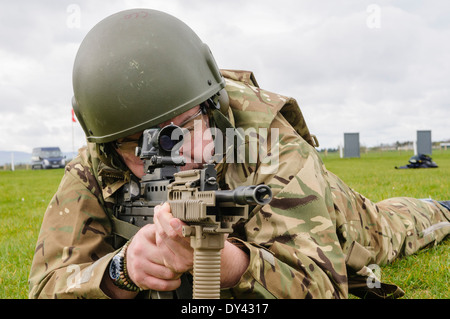 Un soldat de l'armée britannique se trouve en décubitus ventral sur un champ de tir avec une SA80 L85A2 Assault Rifle Banque D'Images