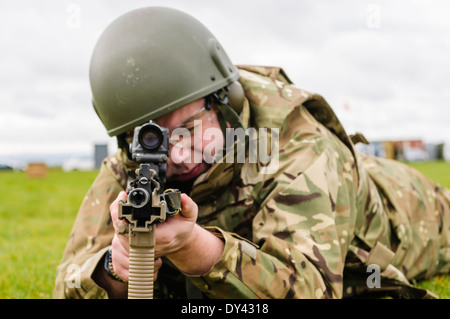 Un soldat de l'armée britannique se trouve en décubitus ventral sur un champ de tir avec une SA80 L85A2 Assault Rifle Banque D'Images