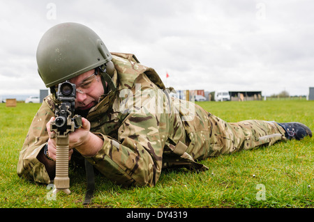 Un soldat de l'armée britannique se trouve en décubitus ventral sur un champ de tir avec une SA80 L85A2 Assault Rifle Banque D'Images