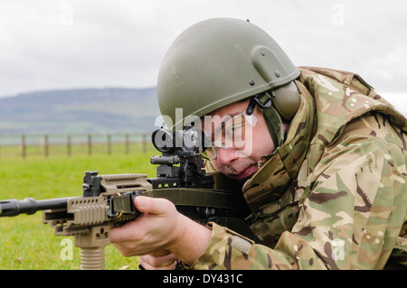 Un soldat de l'armée britannique se trouve en décubitus ventral sur un champ de tir avec une SA80 L85A2 Assault Rifle Banque D'Images