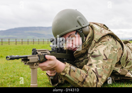 Un soldat de l'armée britannique se trouve en décubitus ventral sur un champ de tir avec une SA80 L85A2 Assault Rifle Banque D'Images