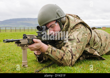 Un soldat de l'armée britannique se trouve en décubitus ventral sur un champ de tir avec une SA80 L85A2 Assault Rifle Banque D'Images