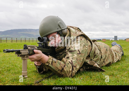 Un soldat de l'armée britannique se trouve en décubitus ventral sur un champ de tir avec une SA80 L85A2 Assault Rifle Banque D'Images