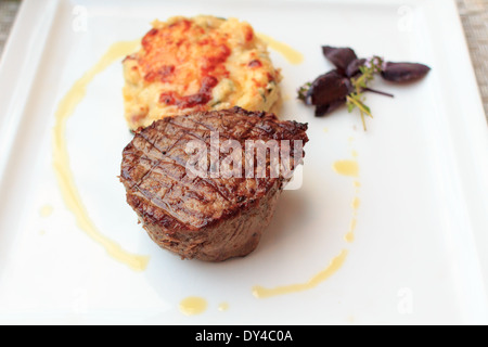 Pavé de boeuf avec un gratin de pommes de terre sur une plaque Banque D'Images