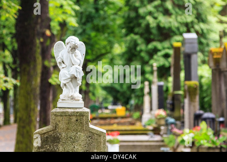 Un deuil blanc porcelaine ange sur une croix au cimetière Mirogoj, Zagreb, Croatie Banque D'Images