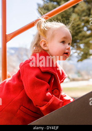 Mignon, adorable petite fille de 16 mois à l'affiche sur un parc jeux pour enfants Banque D'Images