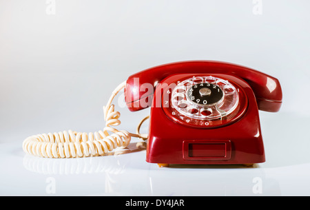 Vintage téléphone rouge sur fond blanc. Le câble blanc Banque D'Images