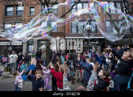 Ann Arbor, Michigan, USA. 6ème apr 2014. Les enfants s'amuser avec des bulles de savon géantes, qui prennent la forme d'une sorte de créature amphibie sur la rue Main à Ann Arbor comme Festifools la parade annuelle a lieu. Les étudiants de l'Université du Michigan et les résidents locaux construit papier mâché création d'art public et les amener à la vie devant des milliers d'Ann Arborites chaque printemps pour lancer la saison des festivals. Credit : Mark Bialek/ZUMAPRESS.com/Alamy Live News Banque D'Images