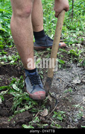 Les jambes d'un homme perdre le sol avec une fourche Banque D'Images