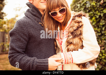 Couple holding hands laughing, cropped Banque D'Images