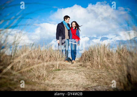 Couple en train de marcher dans les dunes de sable, Bournemouth, Dorset, UK Banque D'Images