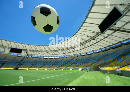 Ballon de soccer Football vol au-dessus de l'herbe vert vif hauteur du stade Banque D'Images