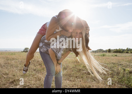 Young woman giving ami piggy back