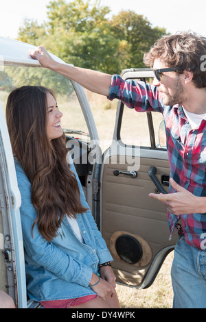 Jeune couple talking by campervan Banque D'Images