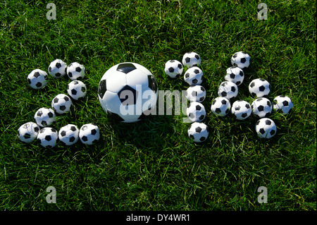 Message pour 2014 faite avec de petits ballons de football sur terrain de football en herbe vert foncé Banque D'Images