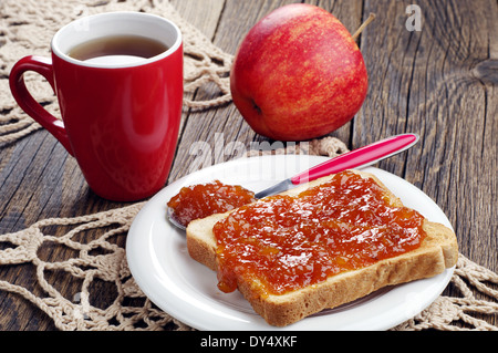 Griller le pain avec de la confiture et une tasse de thé sur la table en bois Banque D'Images