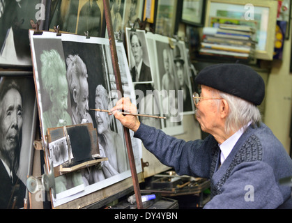 Artiste vietnamien maculage taches graphite avec stick de rendre exemplaire (s) de photographie(s) pour les personnes à acheter - Hanoi, Vietnam Banque D'Images