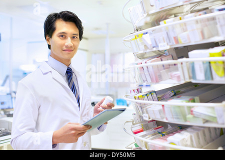 Portrait d'homme pharmacien la prise de stock en pharmacie Banque D'Images