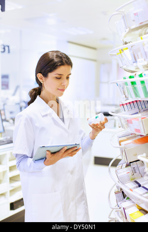 Young female pharmacist la prise de stock en pharmacie Banque D'Images