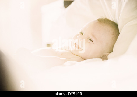 Smiling baby boy lying in crib Banque D'Images