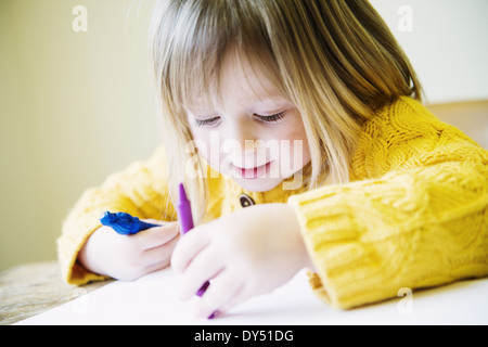 Jeune fille à la table de cuisine à colorier avec des feutres Banque D'Images