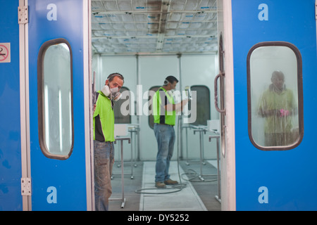 Les hommes qui travaillent dans l'atelier de peinture au pistolet Banque D'Images