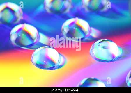 Macro de gouttes d'eau sur fond arc-en-ciel. Banque D'Images