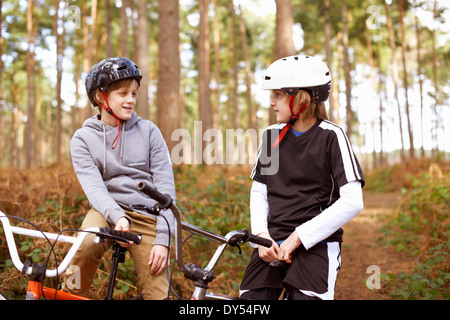 Les frères jumeaux sur vélos BMX chatting in forest Banque D'Images