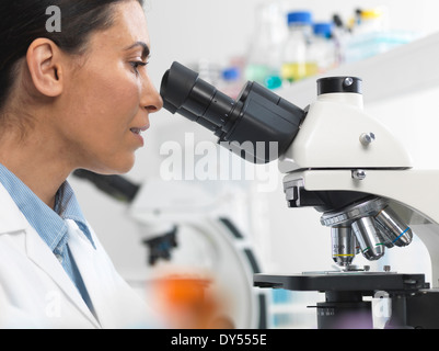 Female scientist viewing diapositive échantillon pour essai clinique in laboratory Banque D'Images