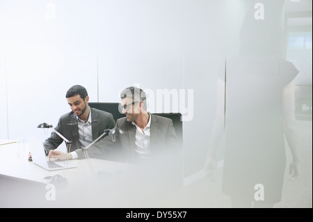 Des collègues masculins using digital tablet in office Banque D'Images